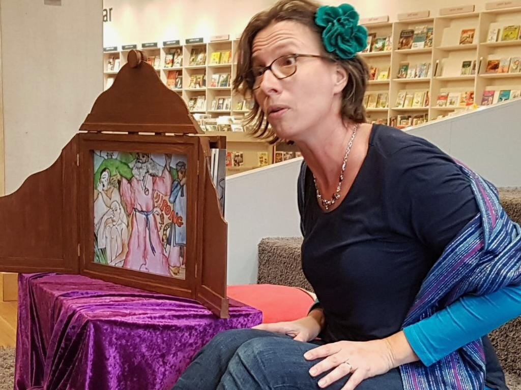 Storyteller Melanie Plag vertelt met behulp van een kamishibai vertelkastje in de bibliotheek.